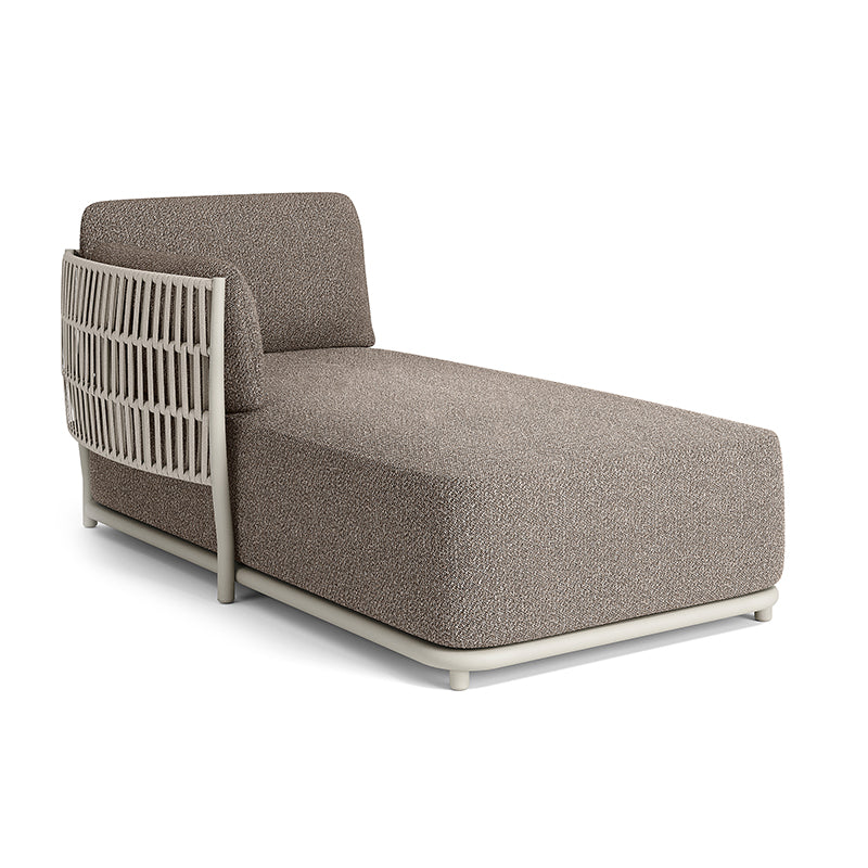 A modern, minimalist chaise lounge with a gray upholstered seat and a woven rattan back and frame.